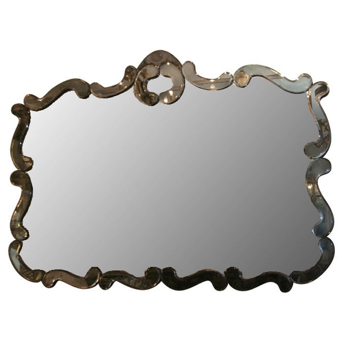 A horizontal rectangular American “Venetian” mirror with cartouche shaped frame having beveled smoke colored mirror border in sections.