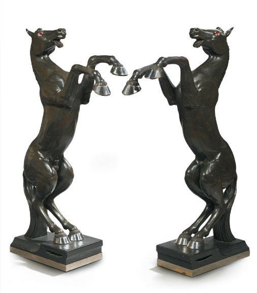 A pair of rare and spectacular horse figured floor lamps in ebonized wood, design circa 1950 by Maison Jansen. Electrified, each upper hoof fitted with downlights, with red glass eyes and chrome accents.