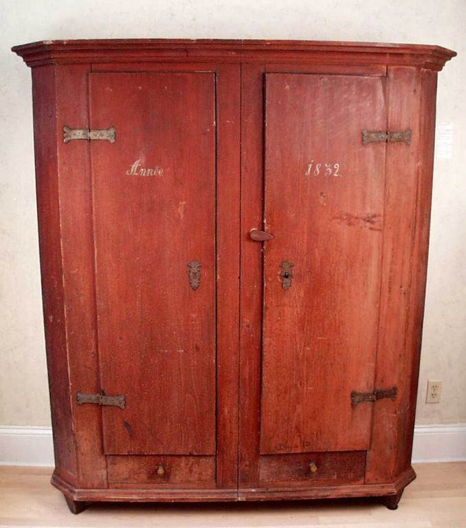 An early 19th Century southern French armoire with 2 doors and 2 drawers; original red paint finish.  With a manuscript date: 1832. Ca. 1830. This armoire was designed and made to come apart into two vertical sections for ease of transport.