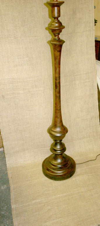 Eine Stehlampe im rustikalen Stil. Die Lampe ist aus Metall und hat eine Holzoberfläche.