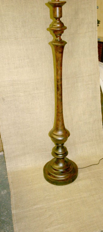 Lampadaire de style rustique. La lampe est en métal et a une finition en bois.
