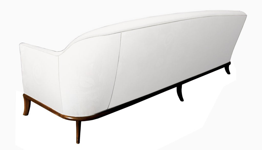 A classically elegant curved back, tufted seat sofa with walnut frame and saber legs. by T. H. Robsjohn-Gibbings C. 1950's<br />
<br />
Measurements:<br />
L: 91'