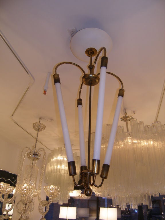 An Italian brass chandelier with tubular light bulbs and an enameled canopy.

In Stock.