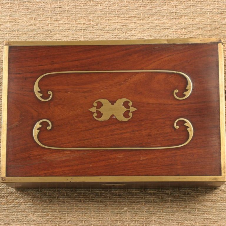 Rosewood jewelry box with decorative brass inlay and protective brass trim. Intricately crafted interior with ivory inlay and delicate frette work. Secret drawer in front of box. Interior has many divided areas for jewelry storage as well as several