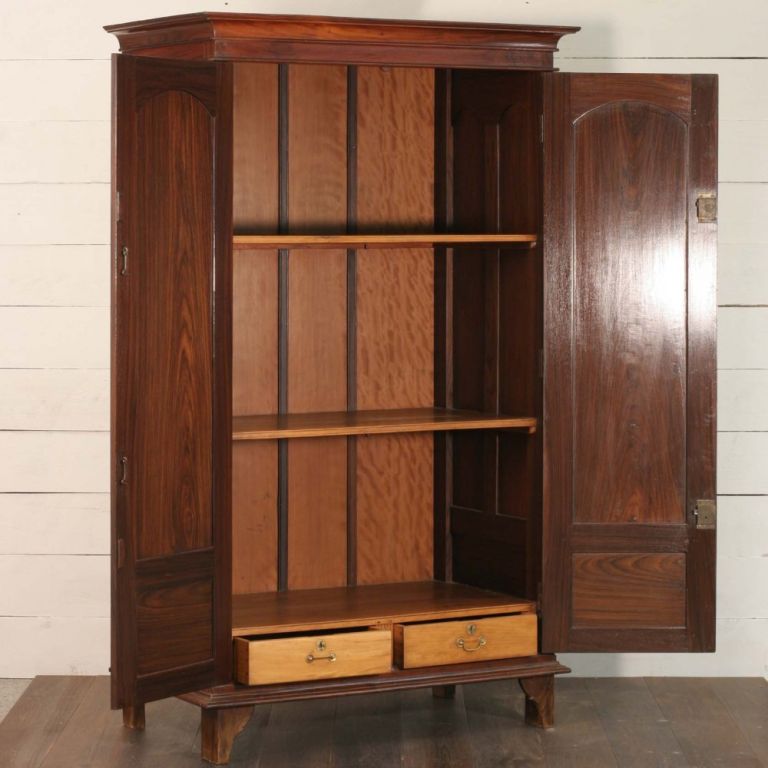 Anglo- Indian rosewood armoire with arched panel doors, double brass locks. Side panels have double arched doors. Armoire has shelves and two satinwood drawers at the bottom of the cabinet.