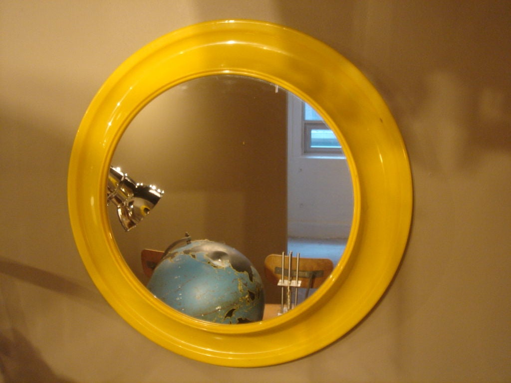 Round yellow mirror in the style of Kartell.  USA, circa 1970.<br />
<br />
Features a deep molded resin frame.