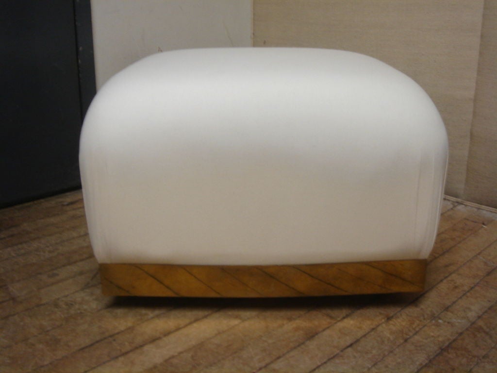 Pouf/ottoman in the style of Karl Springer.  USA, circa 2000.<br />
<br />
Features a brass base with casters; upholstered top with gathered corners.<br />
<br />
Priced individually; multiple ottomans available.  Price of $1,800 includes custom