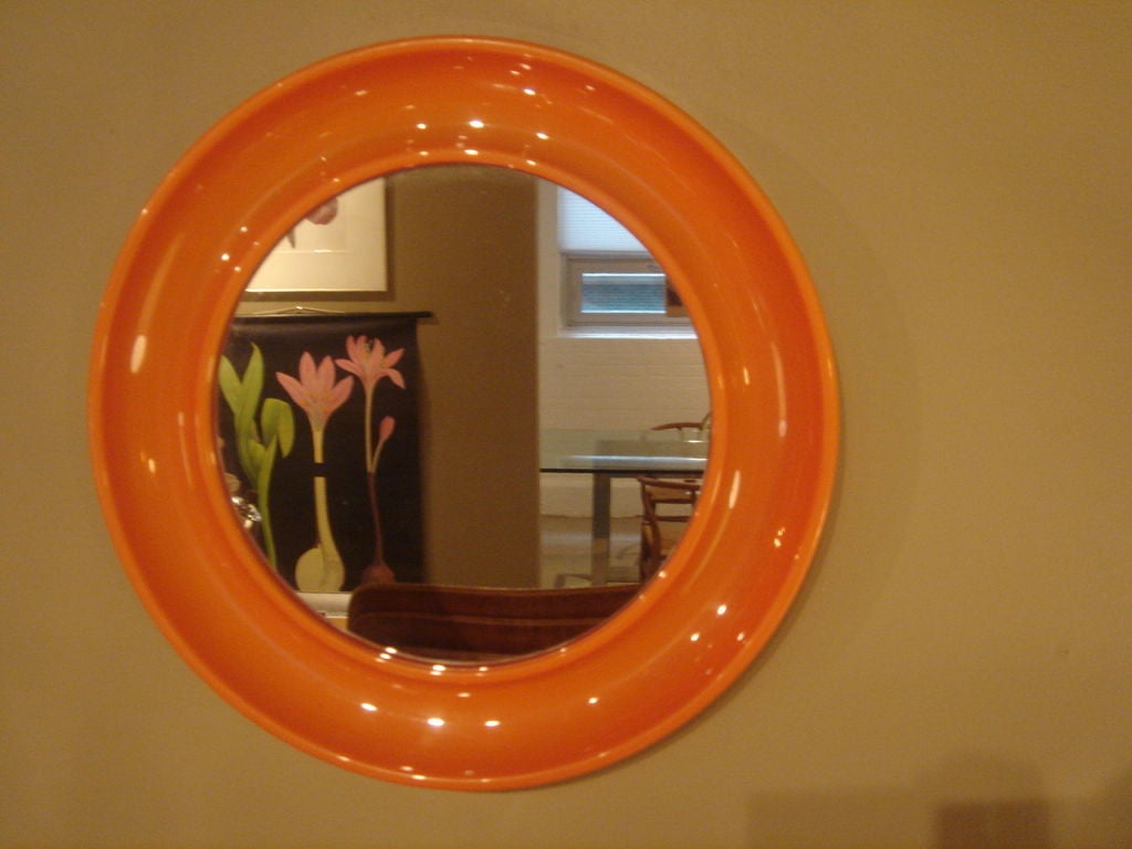 Round orange resin mirror by Collezione Salc.  Canto, Italy, circa 1970.<br />
<br />
Reminiscent of Kartell designs.<br />
<br />
Features a wide and deep molded resin frame.  Signed with label on reverse.<br />
<br />
Item may be viewed at