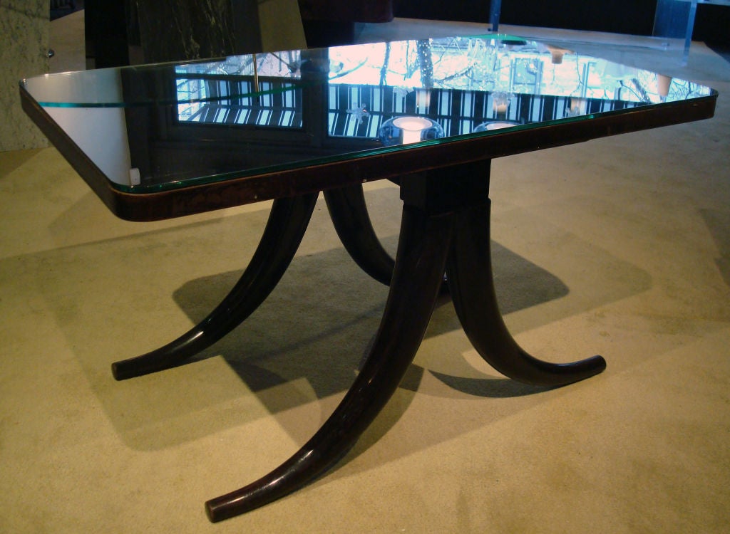 Magnificent cocktail table by Pietro Chiesa for Fontana Arte. Deep stained mahogany base with saber legs, refreshed, French polish finish. Original mirror with minimal patina. Similar example in 
