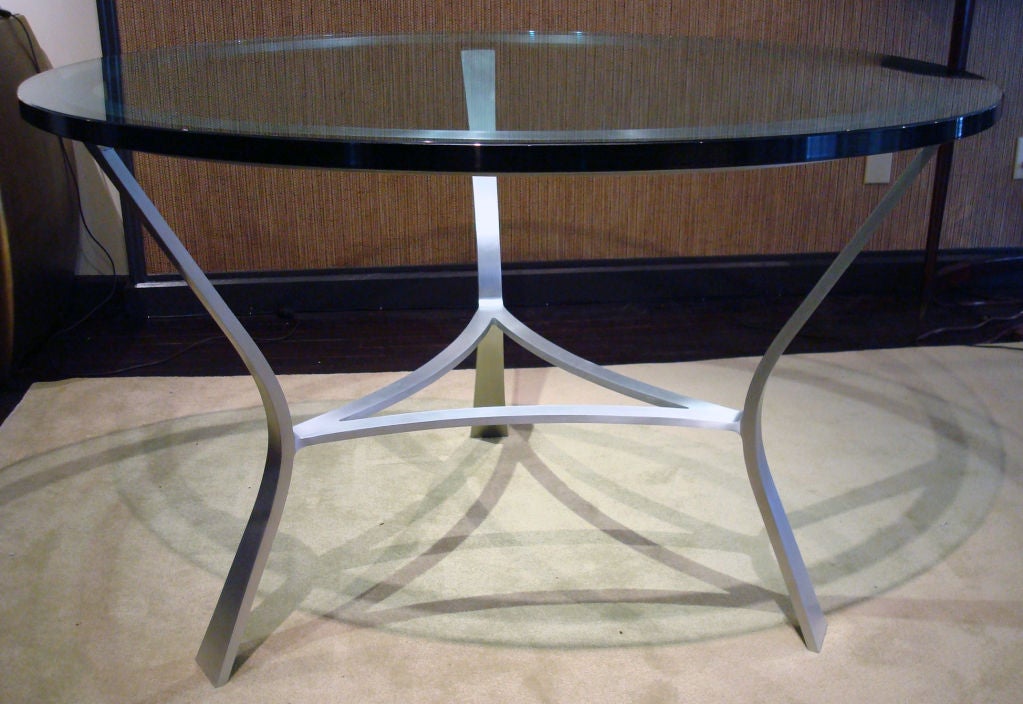 Custom glass top table by John Vesey. Custom design for a Prominent Washington DC Family. The design is shown in a John Vesey catalog as a coffee table. Satin finished aluminum base supports a 1 inch thick glass top. Documented in original John