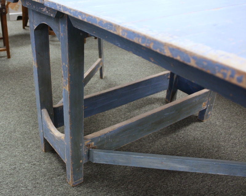 A very early Swedish drop-leaf dining table with original beautiful blue paint.  The worn paint on this piece gives it great antique character.  The 2 drop-leaves are supported by hinged open diagonal legs which tuck away easily for storage(new