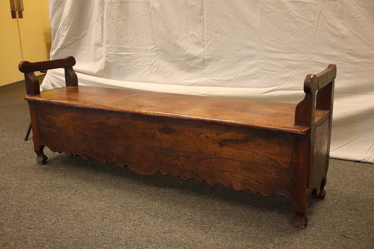 A long antique bench from France. Made of cherry and oak with an exceptionally vivid grain. Note the beautifully shaped apron and feet.<br />
<br />
See similar examples of antique French benches on our website www.BriggsHouse.com.<br />
<br