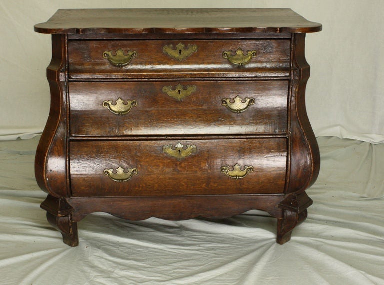 Fabulous Dutch bombe chest. Small in size, but grand in presence. This three drawer bureau is made of rich dark oak with a beautiful color and rich patina. Details of note include all original handles, shaped apron on the front and sides, and a