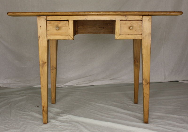 A sweet little English pine desk with a companion Continental chair. Wonderful graining and knot holes, very pretty pine. The nice small size gives this writing table character. Drawers are wide enough apart to allow the chair and its occupant to