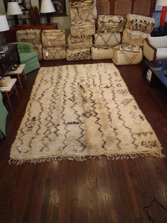 Hand-loomed, Deep pile wool rug with a natural ivory wool field and bold, unusual abstract pattern in dark brown, fringed at one end. Others available.
