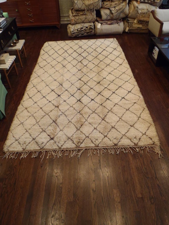 Hand-loomed, Deep pile wool rug with a natural ivory wool field and bold, geometric pattern in dark brown, fringed at one end. Others available.