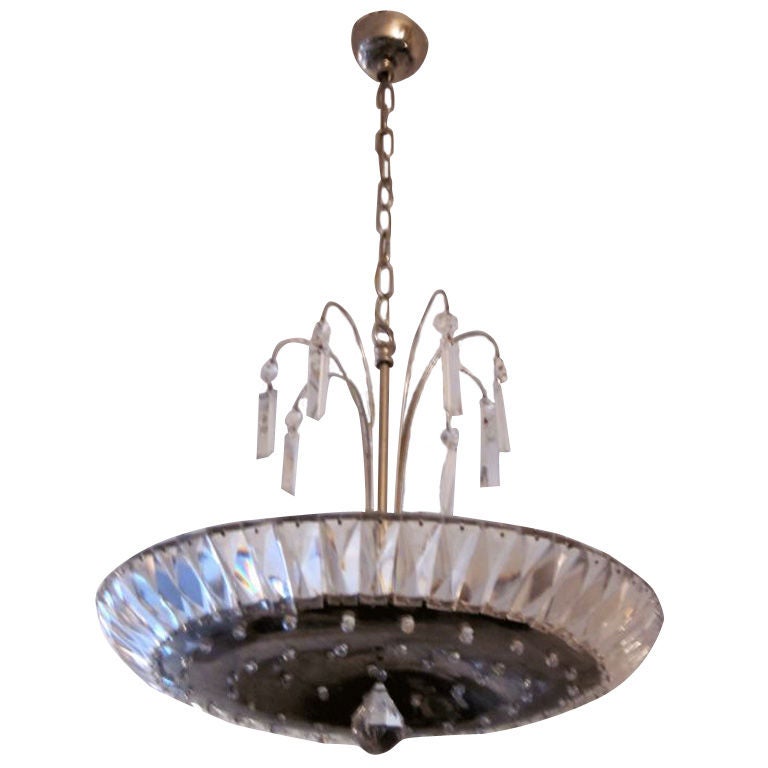 An elegant French midcentury crystal chandelier/fixture embracing neoclassicism and modernity.

The piece has a silvered nickel metal center plate that is im-bedded with cut crystal and central hanging ball. Sockets are secluded above the central