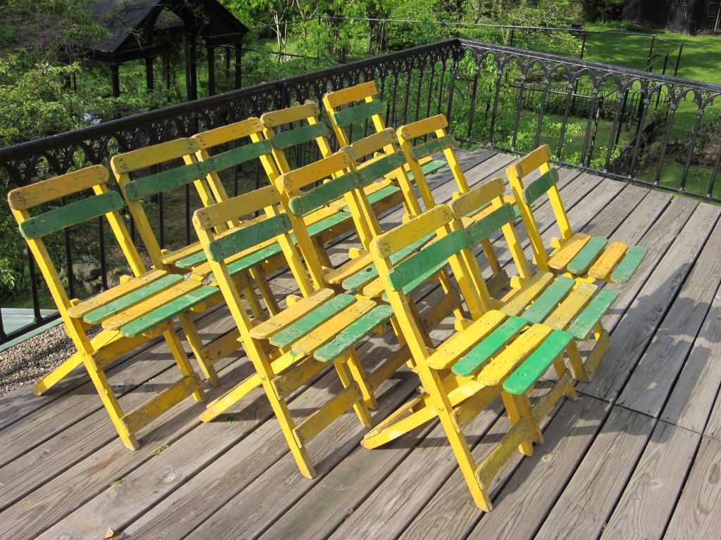 A rare, original ensemble of 12 early 20th century or French Art Deco / Early Mid-Century Modern hand painted wood dining, cafe or garden chairs. The pieces have a stunning appearance with their bright complimentary colors and express a modern