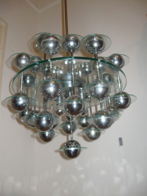 This unusual item was not a mass produced fixture and is a rare find. Comproised of thick cut cystal disc suspended between chromium plated heavy steel elements and equidistant cut crystal discs. Quite a mouthful of a description, but worth every