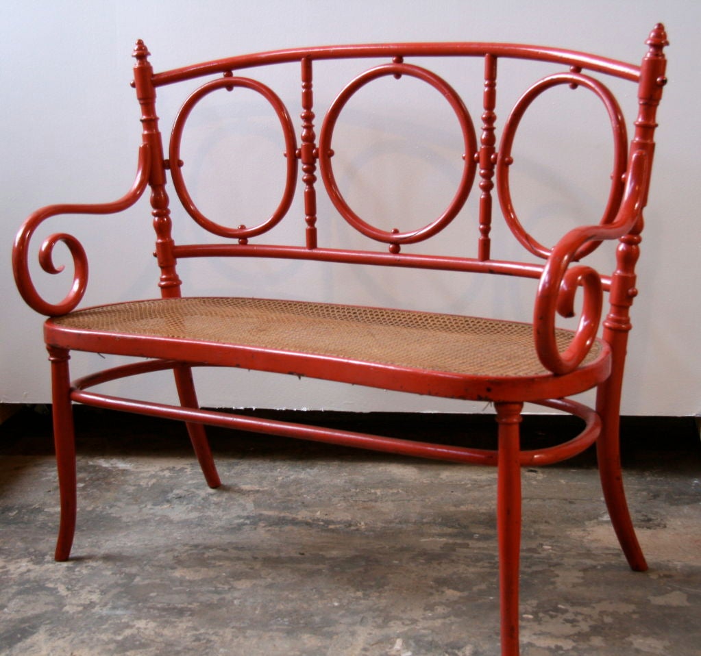 Charming painted bentwood Thonet bench with red paint and caned seat. Found in Northern Italy. Can't you just see it in your breakfast nook while sipping your 1st or 2nd or 3rd espresso...