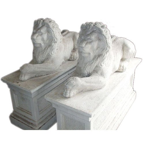 Pair of composition stone lions on bases. For Sale