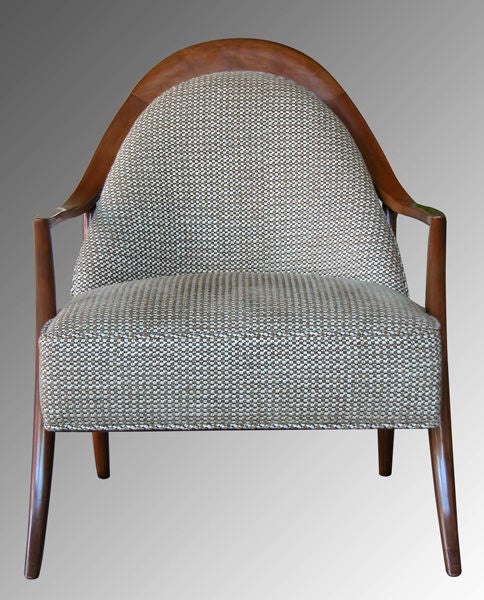 A sleek American mid-century armchair by T.H. Robsjohn Gibbings for Widdicomb; the arching crest above an incurved upholstered back joining a generous square seat; flanked by gently sloping arms raised on elegant splayed supports