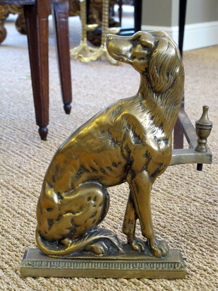A well-executed pair of English brass dog-form andirons; each opposing seated dog with heads facing apart resting on a rectangular plinth