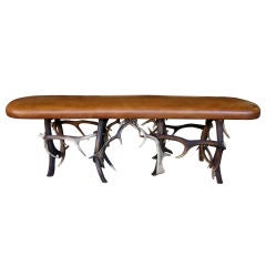 A Rustic Belgian Leather-Covered Bench with Stag Horn Supports