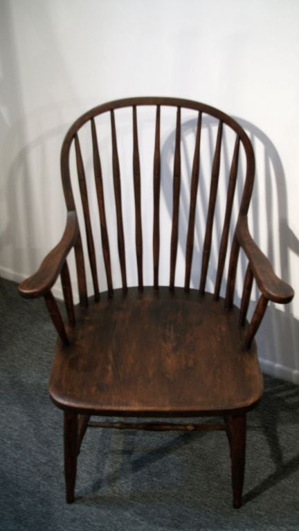 THIS EXTENDED ARM 19THC WINDSOR CHAIR HAS A WONDERFUL DARK SURFACE STAIN W/A WONDERFUL WORN PATINA TO THE SEAT. THE WOOD IS CHESTNUT AND CONDITION IS GOOD. THIS CHAIR IS STRONG AND STURDY AND YET COMFORTABLE.