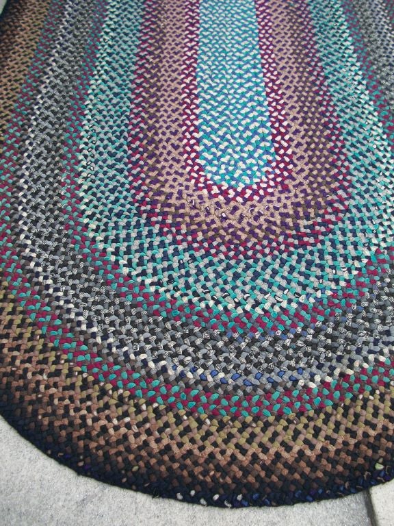 1920'S OVAL BRAIDED WOOL RUG IN PRIMARY COLORS. THE CONDITION IS GOOD. THE COLORS ARE OLIVE, GREEN, BLACK, BROWN, PURPLE, BLUE.