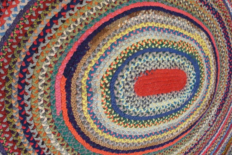 20TH C. MULTI-COLORED WOOL OVAL BRAIDED RUG W/RED CENTER