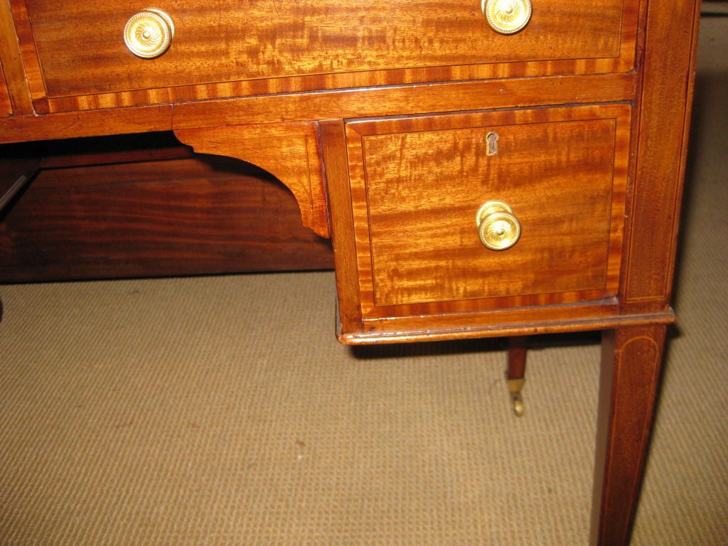 Nice small scale mahogany desk with leather top and brass castors