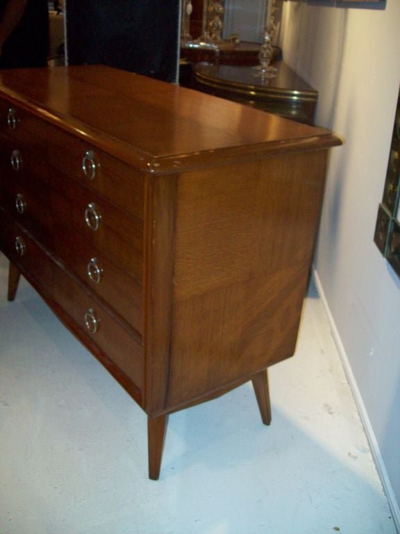 Mid century modern oak five drawer commode with reverse grain veneer and brass ring pulls on flared legs circa