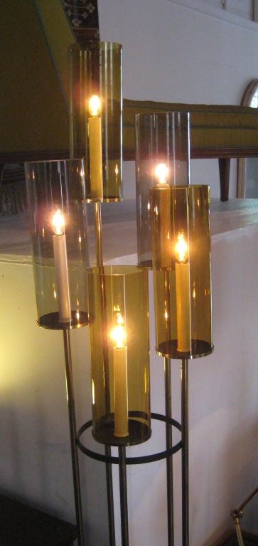 Elegant candelabra-style floor lamp composed of tiered, colored glass hurricane shades on solid brass stems.