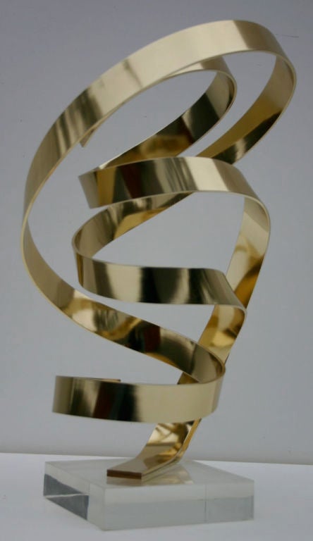 Polished brass ribbon sculpture, signed Dan Murphy 1989. Lucite 6.5
