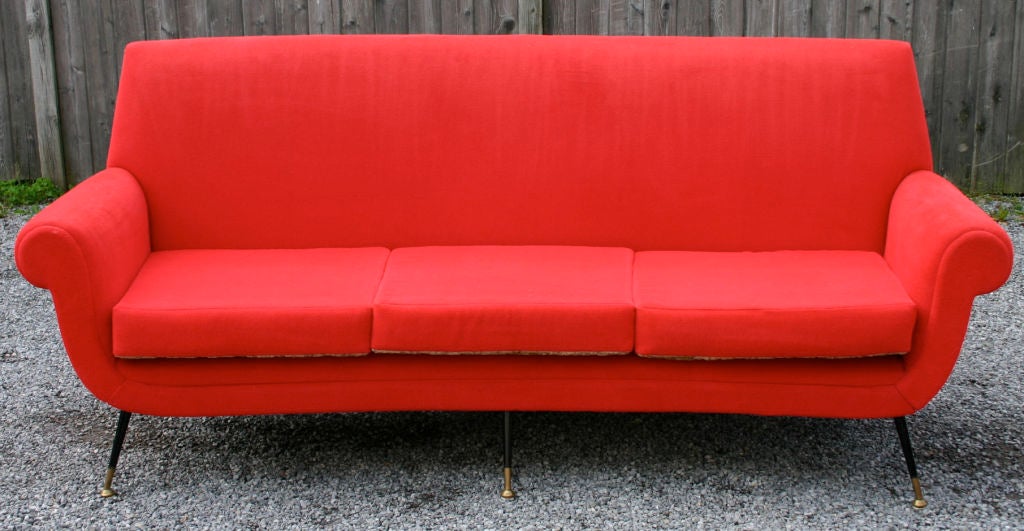 Exquisite modern Italian sofa in vintage bright red stretch cotton velvet; with black metal legs and brass feet by Gigi Radice for Minotti. Matching pair armchairs also available.