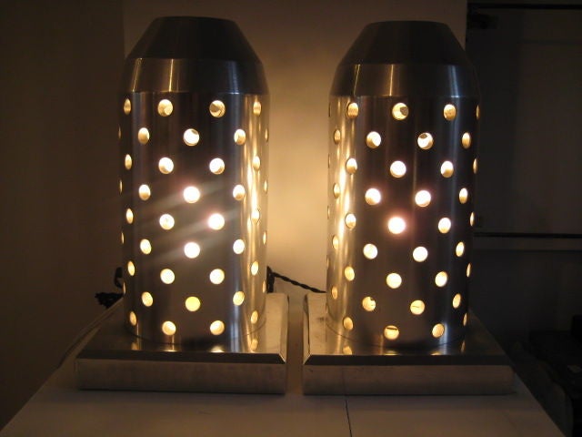 A pair of highly machined, deco style, bullet shaped table lamps-formerly Robert Isabel collection. Very heavy and well made.