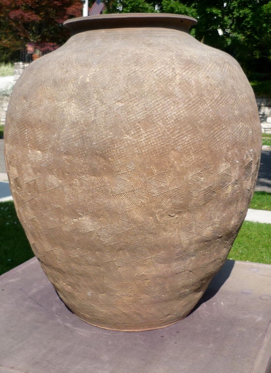 WARRING STATES PERIOD / WESTERN HAN DYNASTY POTTERY JAR WITH STAMPED DECORATION

The wide shoulders tapering sharply down to a flat base, the exterior crisply impressed with a checkered pattern composed of small cross-hatched square and