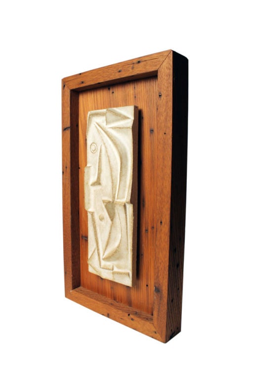 A ceramic tile with an abstract design in high relief mounted within a wooden shadow box. By Design Technics. American, circa 1960.