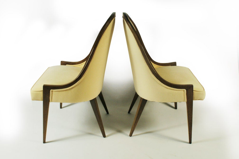 A pair of Mid-Century Modern 'gondola' form pull up slipper chairs with a graceful mahogany frame and splayed rear legs. By Harvey Probber. U.S.A., circa 1950s. [DUF0423] [DUF0424] [DUF0425] [DUF0426] [DUF0603]