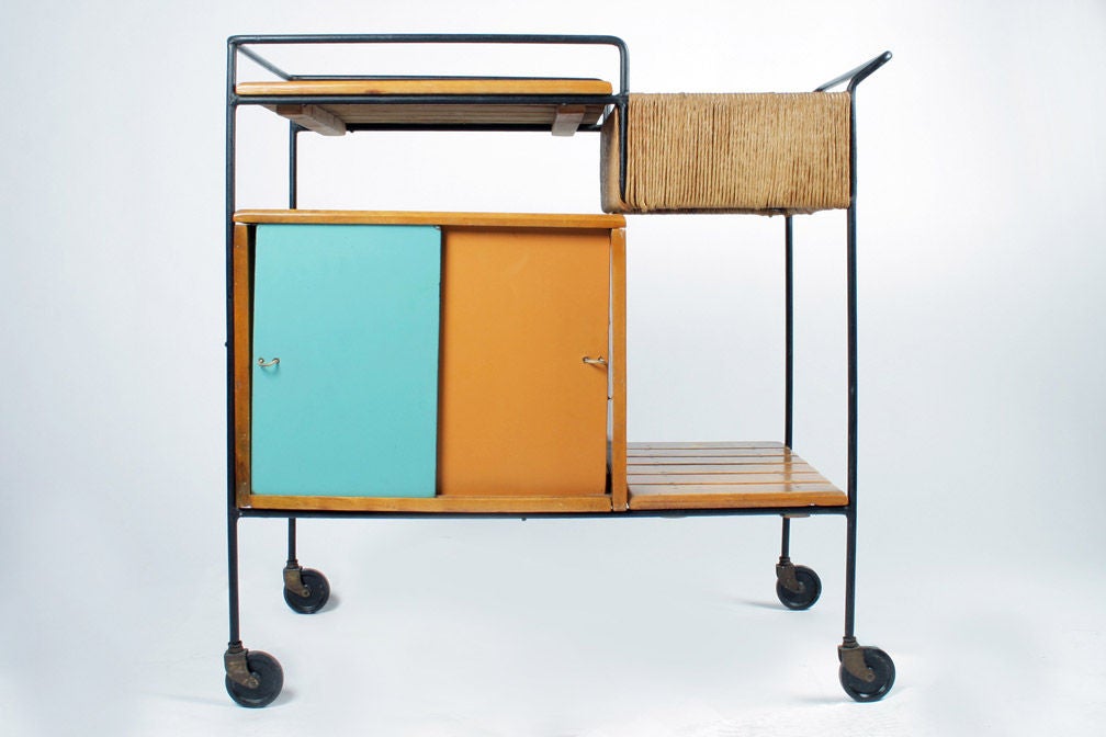 A Mid-Century Modern serving cart with a black wrought iron frame, wood slat shelving and case, sliding lacquered doors in caramel and aqua, and woven rush upper compartment; the whole resting on casters. By Arthur Umanoff for Raymor. American,