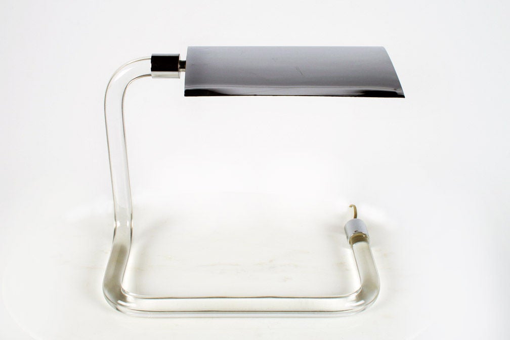 The 'Crylicord' desk lamp consists of an adjustable chrome shade, chrome fittings and a formed Lucite rod arm and base in one. By Peter Hamburger for Kovacs. American, circa 1970.
