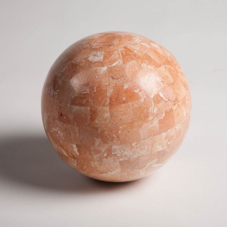 A decorative orb sphere in a beautiful salmon colored marble veneer in a tessellated pattern. Mod. no. 10-UF. By Maitland-Smith, Ltd.  Filippino, circa 1980.