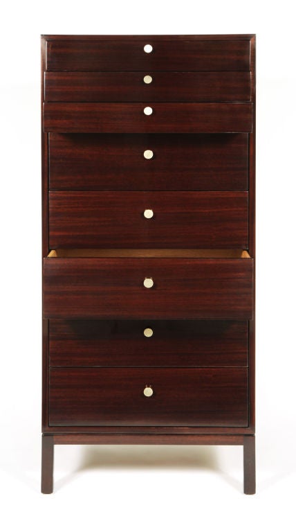 A refined, tall mahogany cabinet comprising three shallow drawers and five deep drawers all with satin brass hardware, the whole resting on a square legged base. With metal stamp to interior top drawer.  By Harvey Probber. American, circa 1950.