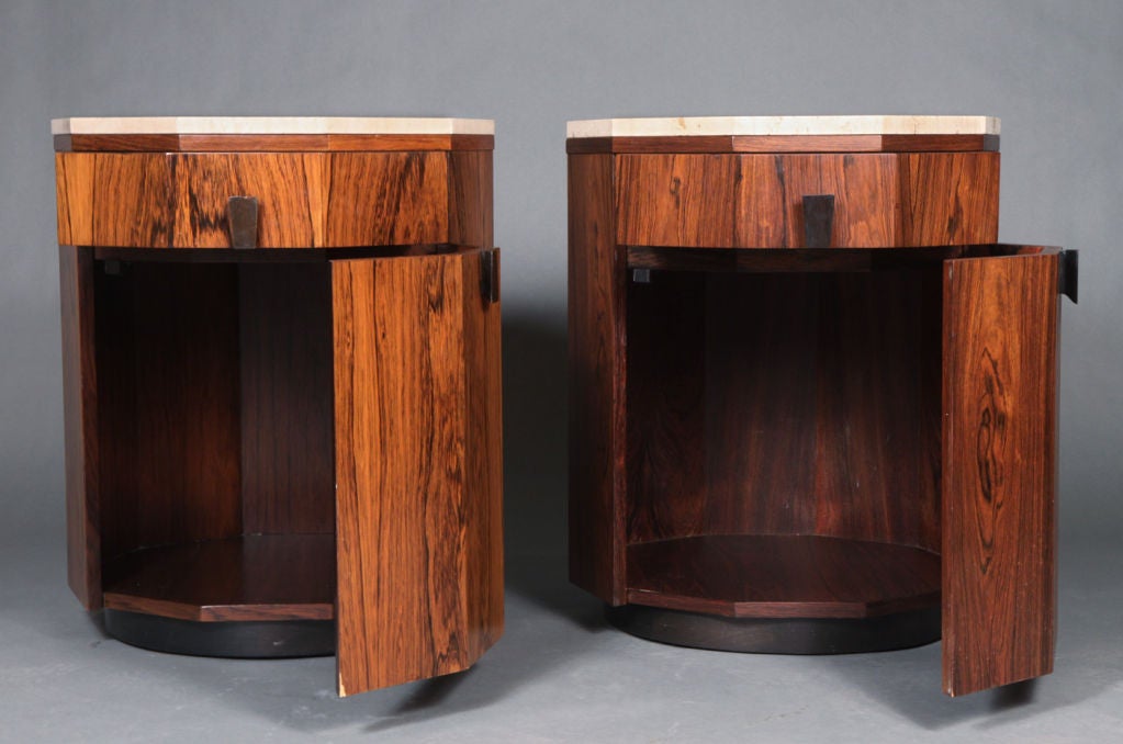 A beautiful pair of ten sided end tables or dry bars in Rosewood with ebonized trapezoidal wood pulls. Upper drawer over door compartment and round wood plinth. Door incorporates two shelves for storing bottles. Designed and produced by Harvey
