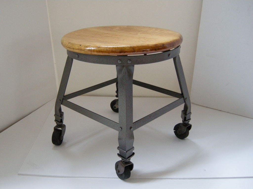 Industrial Iron Stool, on original casters. Maple Wood seat restored, polished iron.