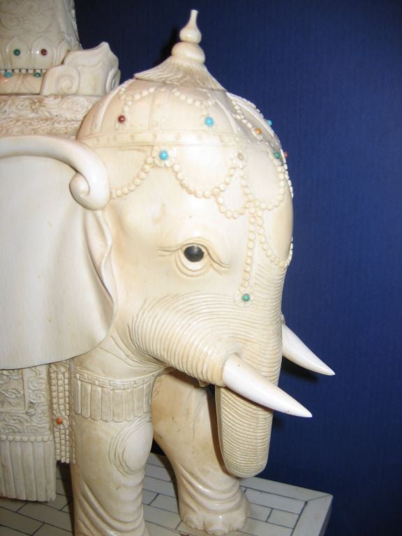 This matched pair of anatomically correct male/female elephants create a striking impression.They measure 30.5' in height.The quality of the carving is exceptional,particularly well represented by the pierced howdahs.Multi-colored applied cabochons
