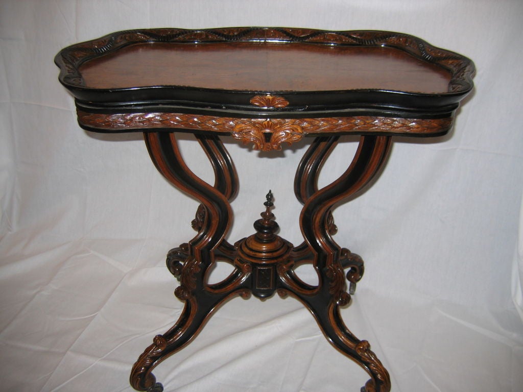 Late 19th century burl and ebonized walnut accent table with pull out candle stands on both ends,are an ideal place to hold a drink .Burl veneer top with an ebonized pie crust lip. The four delicately scrolled  walnut legs are embellished with