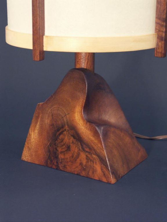 Lovely small scale lamp by Nakshima (provenance available). The black walnut base has a terrific grain pattern, highlighted by the flat cuts adding formality to the otherwise free form. The shade is composed of four walnut uprights, and a pair of
