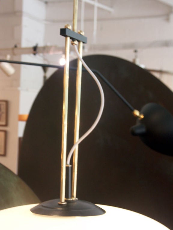 Very unique ceiling lamp, a large frosted glass globe is held by a multi-tier brass suspension arm. An unusual melding of styles, nice for a high ceiling entryway, or intimate dining area.